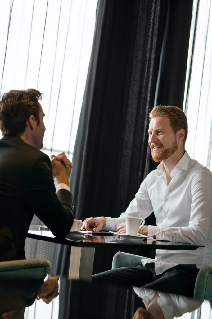 Coffee break. Two cheerful business men talking in a restaurant
