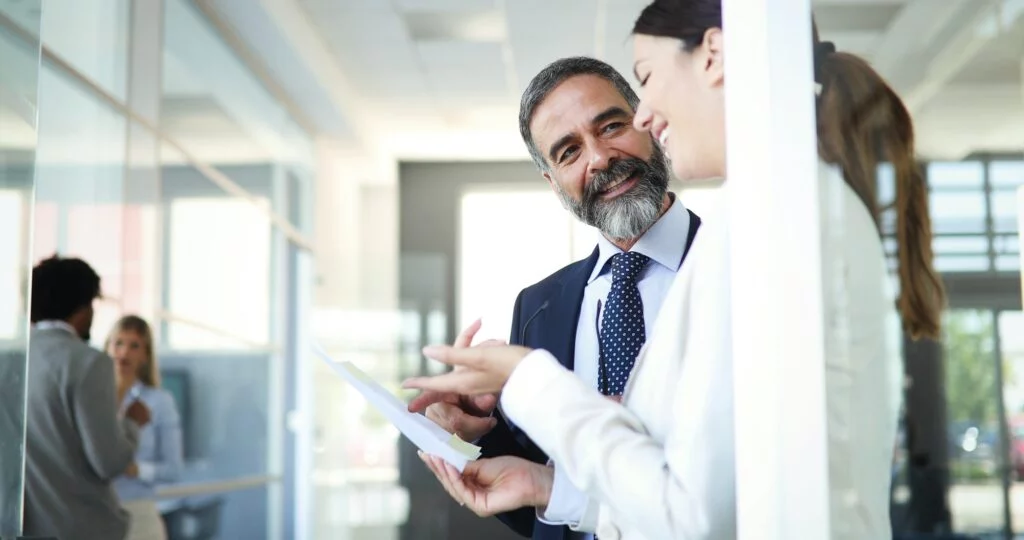Happy business colleagues in modern office smiling and talking